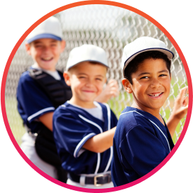 3 kids on fundraised baseball team next to chain link fence