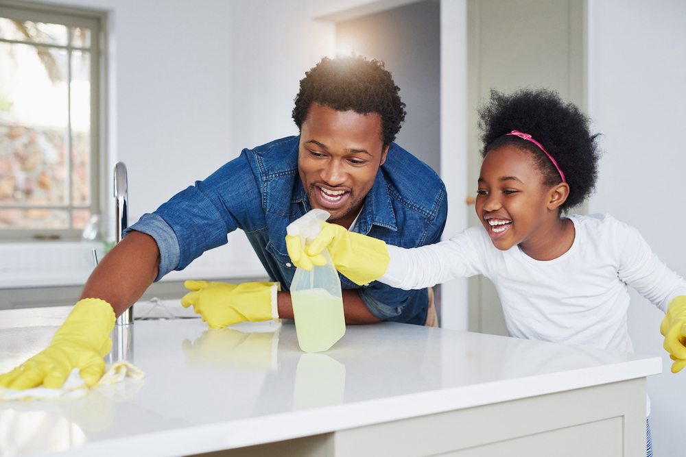 Father and daughter cleaning kitchen together