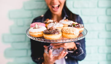 ecstatic_woman_holding_plate_of_donuts.jpg