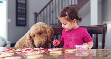 little girl and dog decorating cookies.jpg