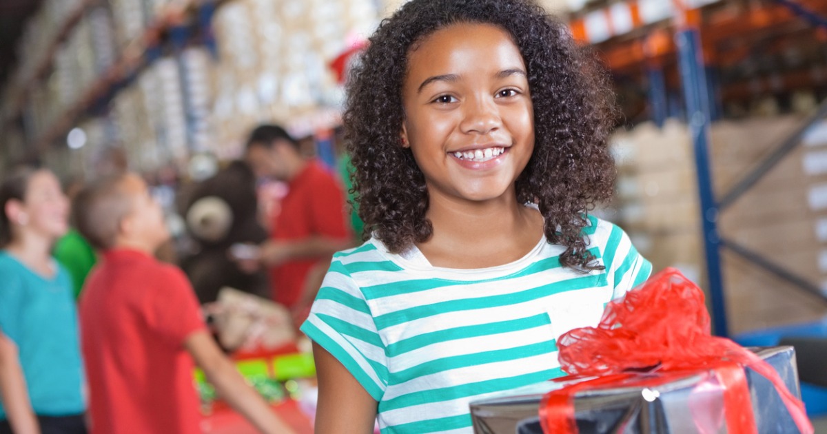 happy-little-girl-donating-christmas-gifts-at-charity-toy-drive-picture-id175380504