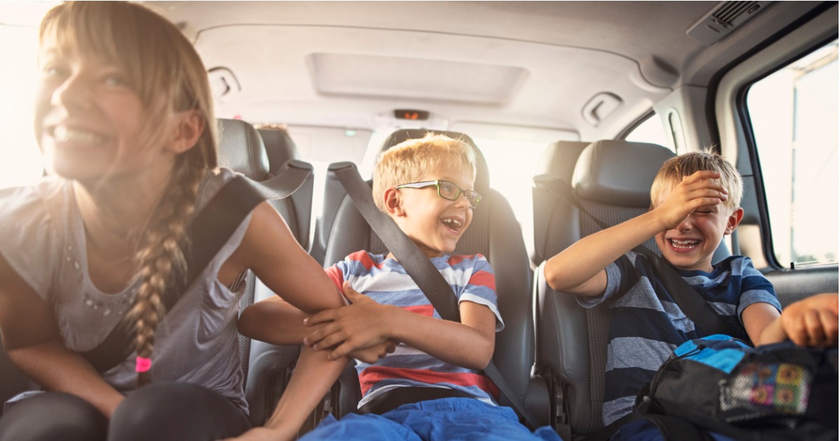 happy-playful-kids-travelling-by-car-picture-id1153359710
