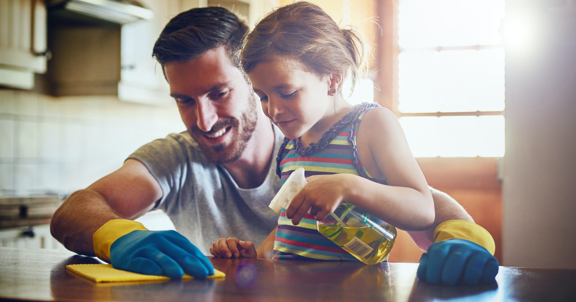 father and daughter cleaning the kitchen countertop