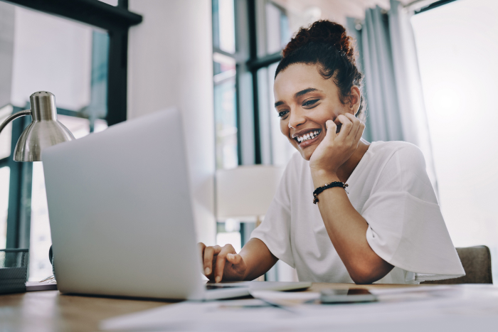 Woman smiling and signing up for RaiseRight from her laptop computer