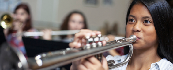 High school female playing trumpet in band class