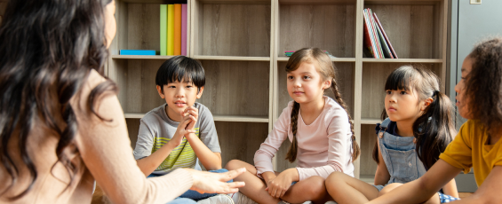 School children sitting on floor with their teacher