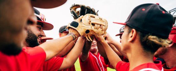 Youth baseball team coach and players raising gloves for high-five