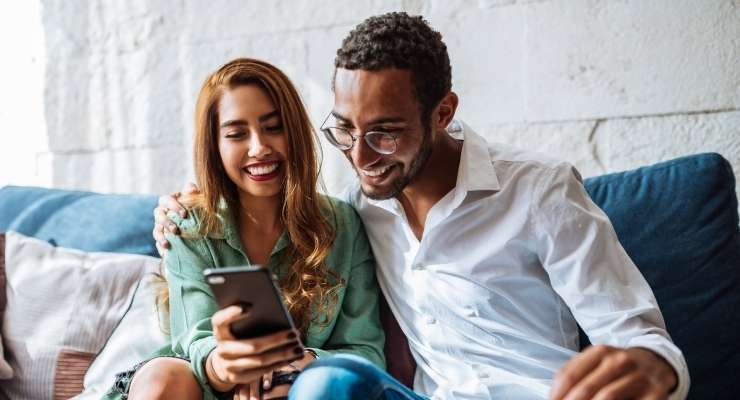 smiling couple checks how much they have raised with gift card fundraising